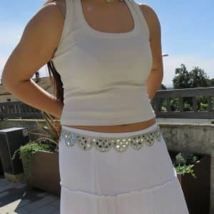 Vestido blanco con accesorios de moda en exterior, ideal para eventos y verano.