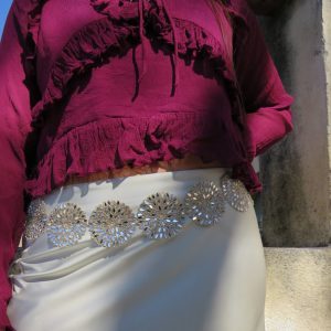 Vestido de fiesta con detalles brillantes y blusa de manga larga en color burdeos.